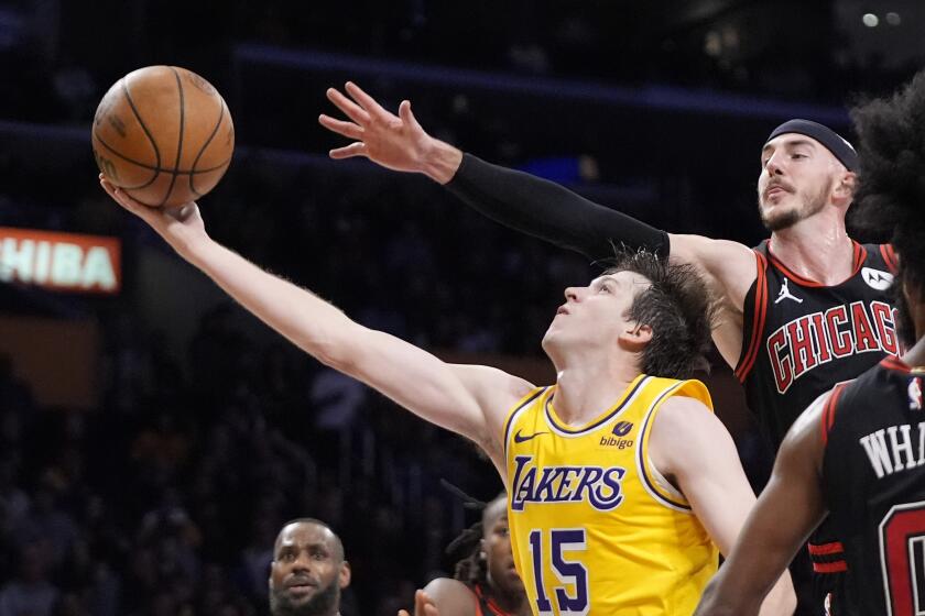 Los Angeles Lakers guard Austin Reaves, left, shoots as Chicago Bulls guard Alex Caruso defends during the second half of an NBA basketball game Thursday, Jan. 25, 2024, in Los Angeles. (AP Photo/Mark J. Terrill)