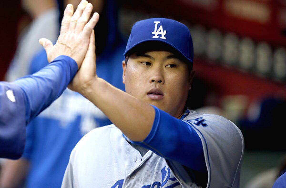 Dodgers pitcher Hyun-Jin Ryu gets a high-five in the dugout before pitching a gem against the Diamondbacks on Friday night in Phoenix.