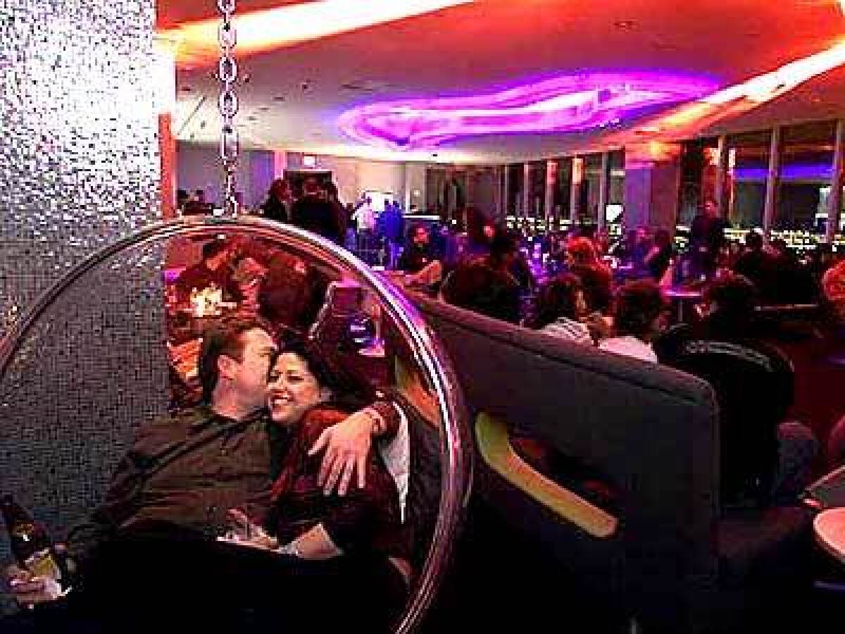 A couple gets cozy in a seat suspended from the ceiling at Ghost Bar on the 55th floor of the Palms, where people-watching is the sport and a $20 cover is the weekend norm.