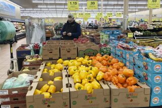 A man looks at his mobile phone while shopping at a grocery store in Buffalo Grove, Ill., Sunday, March 19, 2023. On Wednesday, the Labor Department reports on U.S. consumer prices for March. (AP Photo/Nam Y. Huh)