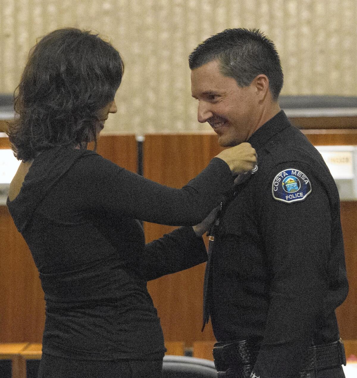 Bryan Glass' wife, Irene, pins on his new captain badge during a Costa Mesa Police Department promotion ceremony in 2015.