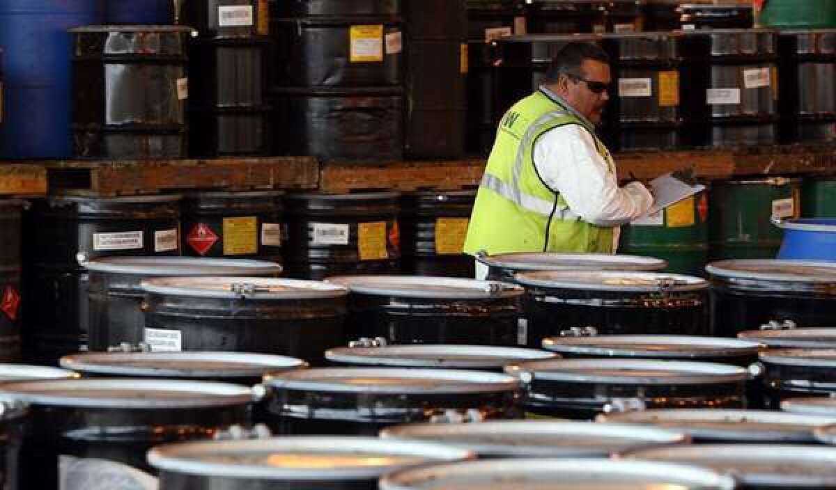 A worker takes inventory of hazardous waste stored in barrels at a Kettleman City facility licensed to accept such dangerous shipments. There are significant gaps in California's laws governing the transport and disposal of hazardous waste, an L.A. Times investigation found.
