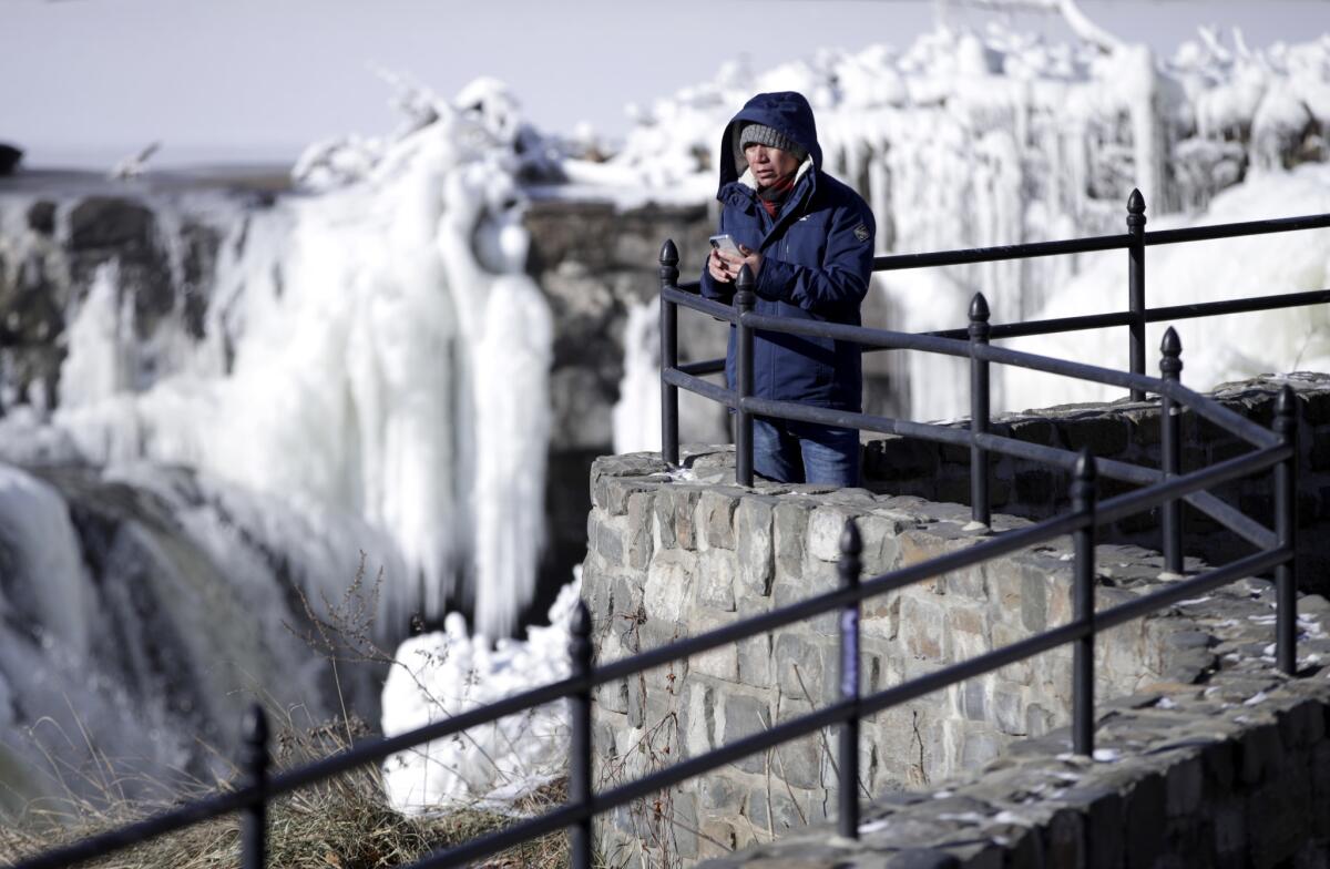 Obdulio Arenas looks over the partially frozen falls at Paterson Great Falls National Historical Park in Paterson, N.J., on Tuesday.