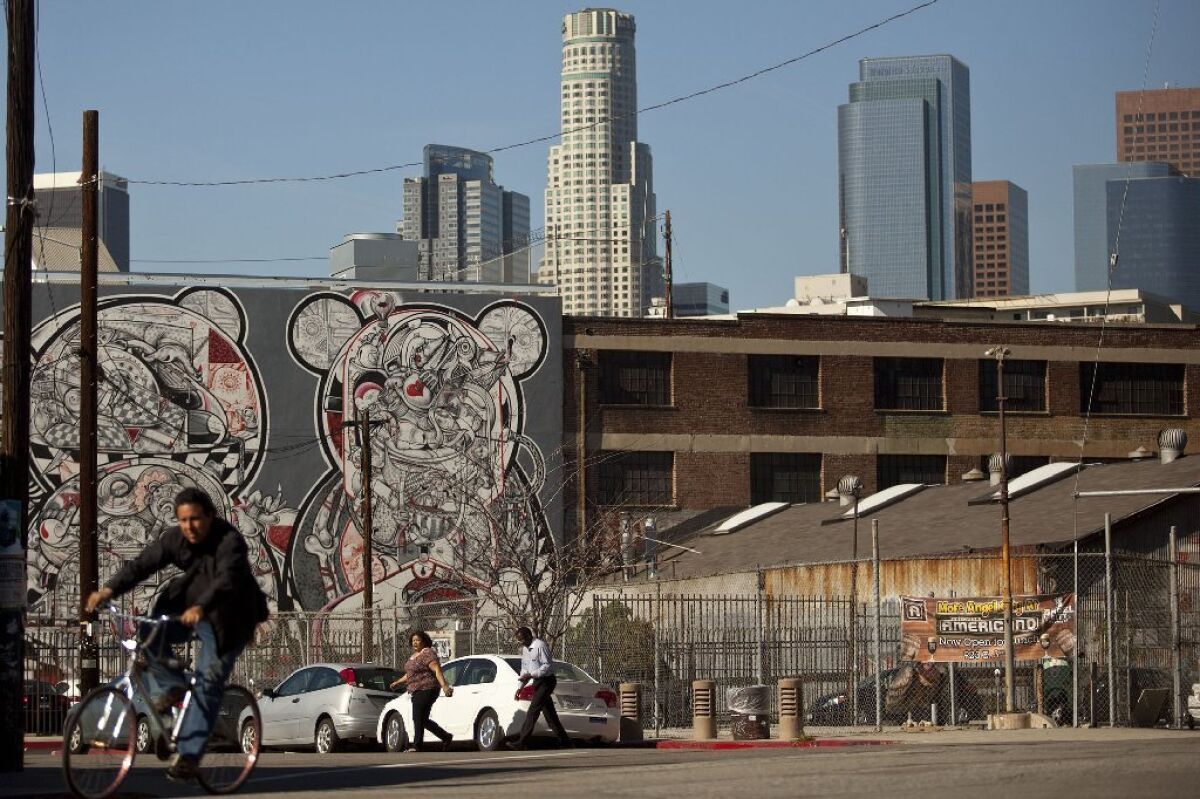 The downtown L.A. skyline overlooks buildings in the arts district near the Los Angeles River.