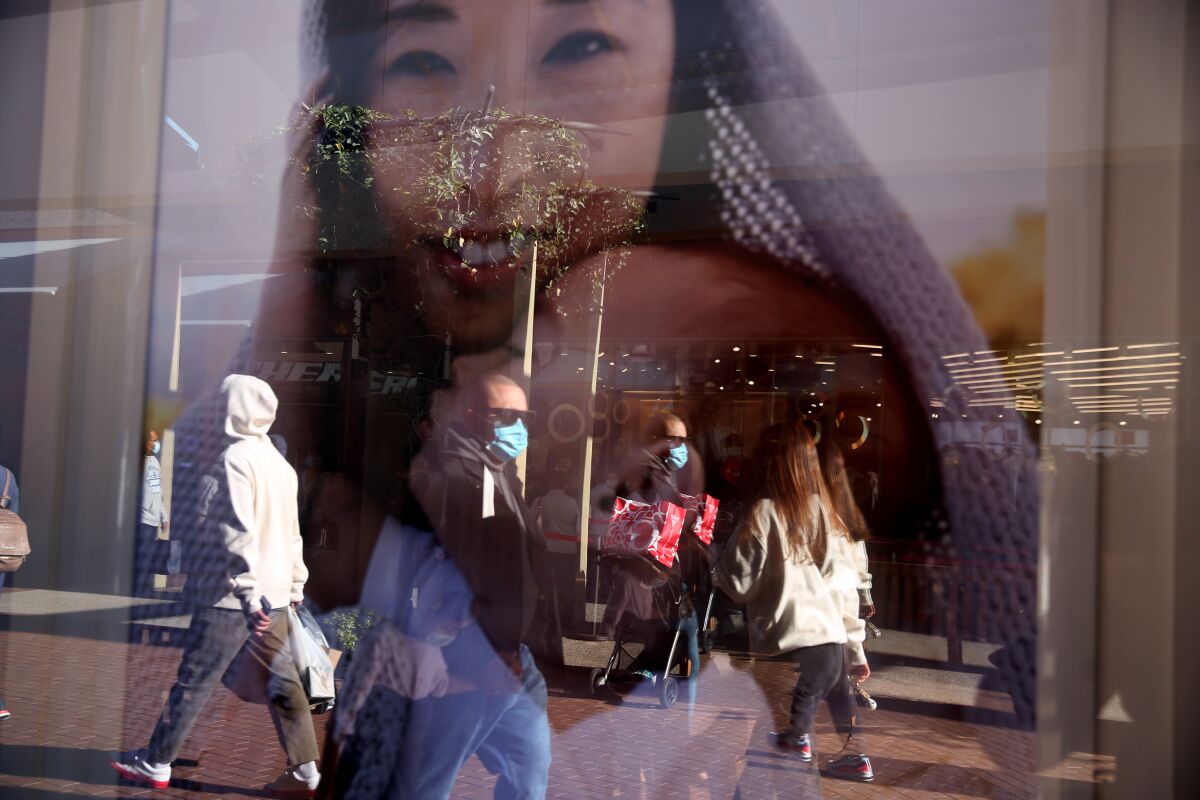 Shoppers at the Citadel Outlets are reflected in a window advertisement in Commerce. 