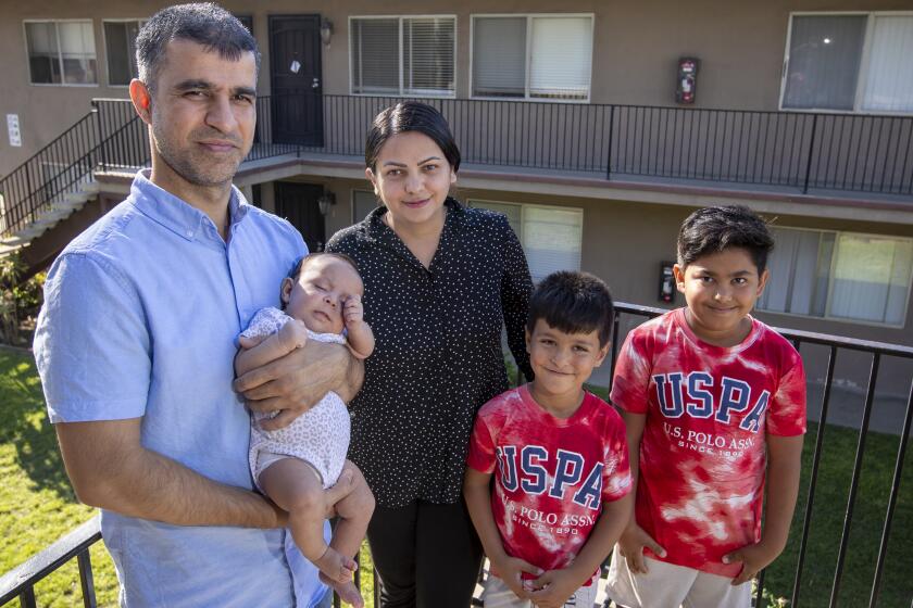 San Diego, CA - September 22: Hamid and Masooda Qazi, shown with their kids Dewa, 2 months old, Hasib, 6, and Habib, 10, at their San Diego apartment. Hamid and Masooda worked as attorneys in their native Afghanistan, with successful careers working for the Afghan and U.S. governments, before the fall of Kabul, when they were forced to flee with their two young sons for their safety. They have since immigrated to San Diego, had a baby girl, and are both looking to re-enter the legal field with some help from local attorneys and judges. Photo taken in San Diego Thursday, Sept. 22, 2022. (Allen J. Schaben / Los Angeles Times)