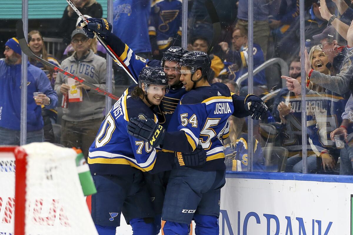 St. Louis Blues' Logan Brown (22), center, is congratulated by teammates Oskar Sundqvist (70) and Dakota Joshua (54) after scoring a goal against the Tampa Bay Lightning during the second period of an NHL hockey game Tuesday, Nov. 30, 2021, in St. Louis. (AP Photo/Scott Kane)
