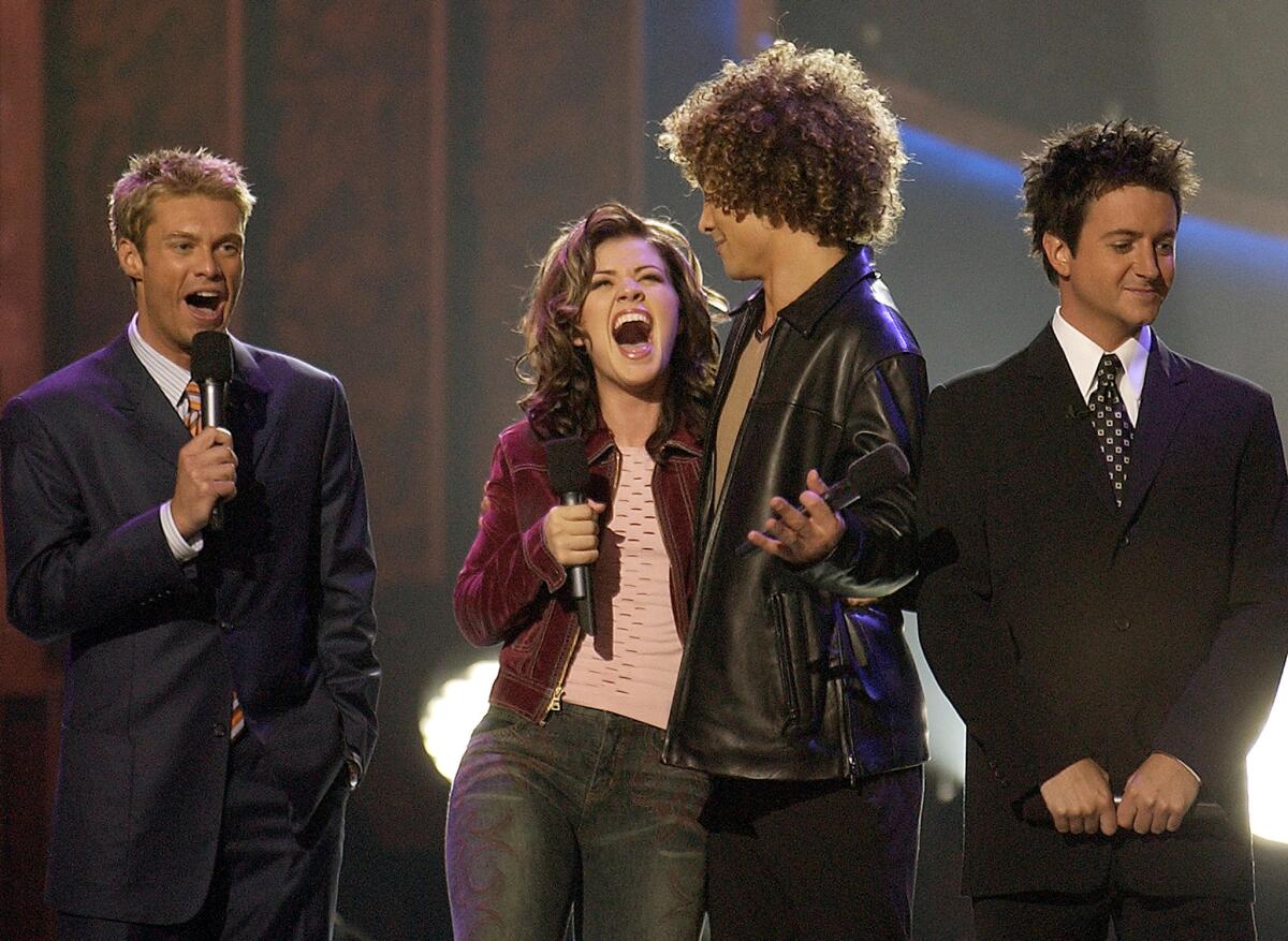 Ryan Seacrest, from left, Kelly Clarkson, Justin Guarini and Brian Dunkleman are shown during the finale of the inaugural season of "American Idol" on Sept. 4, 2002.