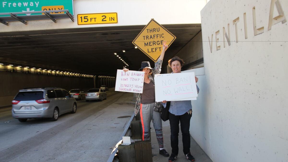 Artists Rachel Mason, left, and Ilona Berger make their way to the protest at LAX.
