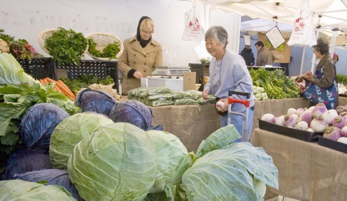 Cabbage and other vegetables grown by Mai Yang, center, in the Fresno County city of Sanger and sold at the Silver Lake farmers market.