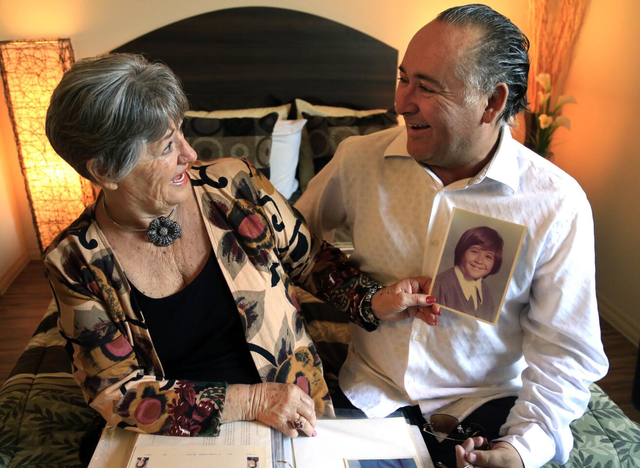 David Abeyta and his mother, Mary Schofield, look over photos of David in his youth after being reunited at SRO Housing Corp.'s Gateway Apartments in Los Angeles.