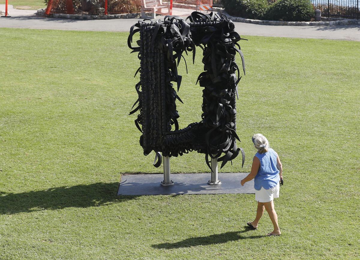 A woman takes a closer look at "Gridlock," a recently installed public art sculpture.