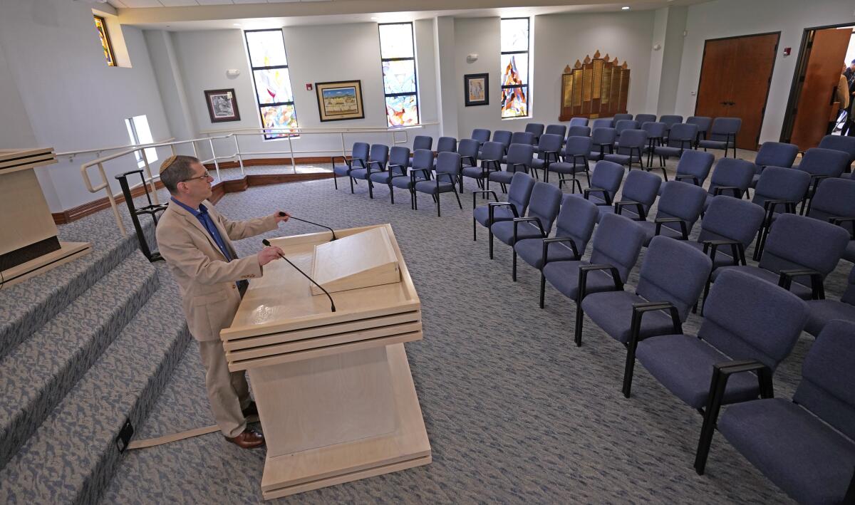 Rabbi Charlie Cytron-Walker adjusts the microphones at Congregation Beth Israel in front of chairs