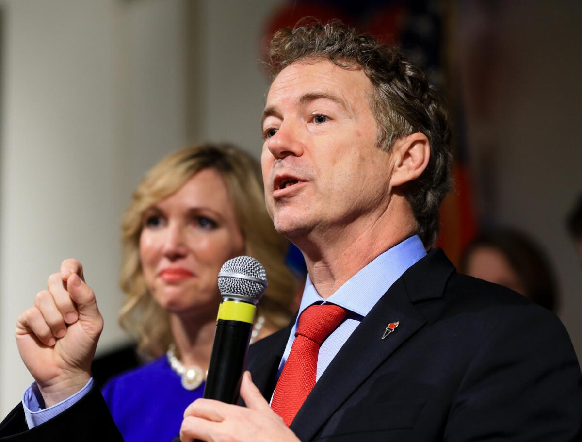 Sen. Rand Paul speaks to supporters with his wife, Kelley, by his side on caucus night in Des Moines.