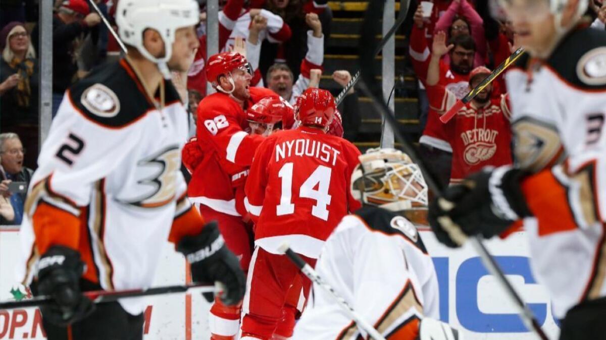 Red Wings defenseman Xavier Ouellet celebrates a goal against the Ducks with his teammates Thomas Vanek (62) and Gustav Nyquist (14) during the second period of a game on Dec. 17.