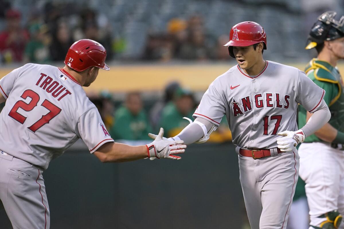 The Angels' Shohei Ohtani (17) is congratulated by Mike Trout after Ohtani hit a two-run, fifth-inning homer May 14, 2022.