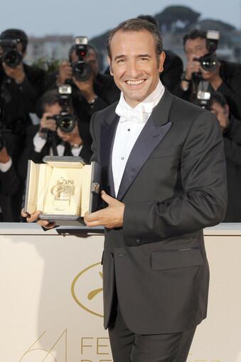 French actor Jean Dujardin poses during a photocall after being awarded with the Prix d'Interpretation Masculine (Best Actor) award at the 64th Cannes Film Festival.