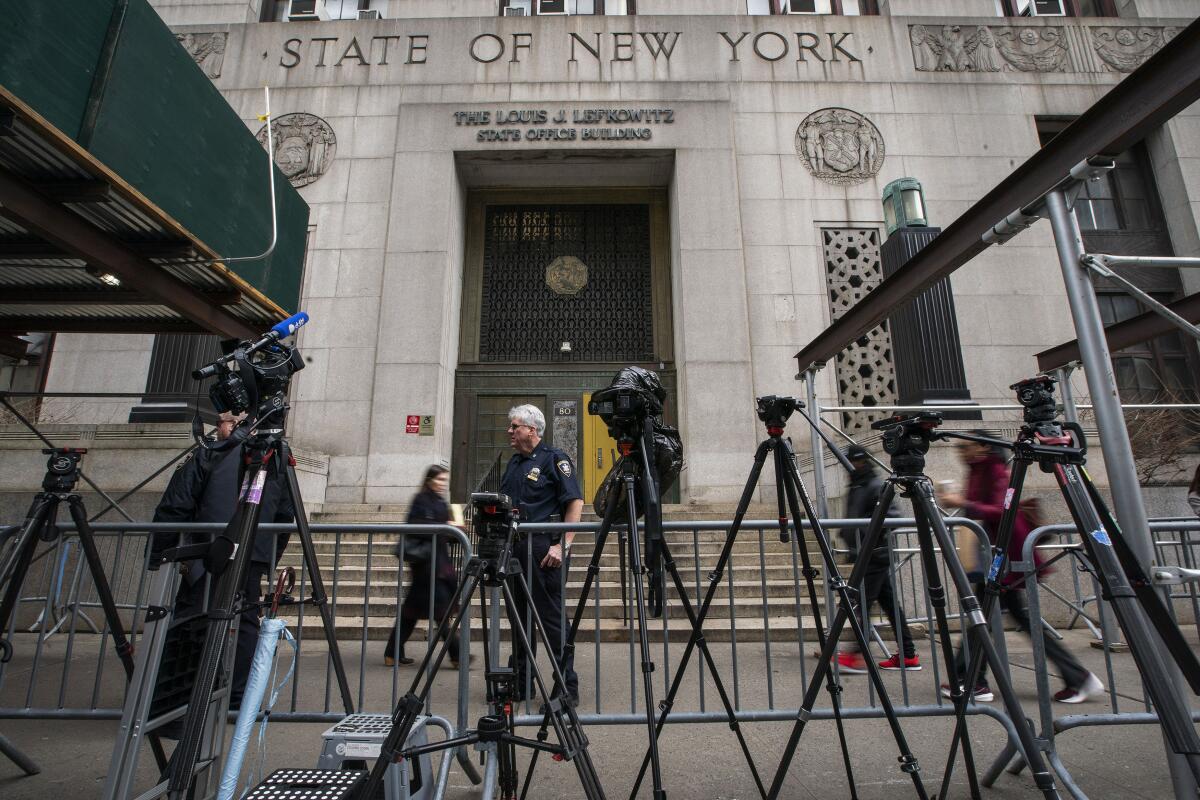 Gente pasa frente al tribunal y cámaras y equipos instalados por la prensa a la espera de la resolución 