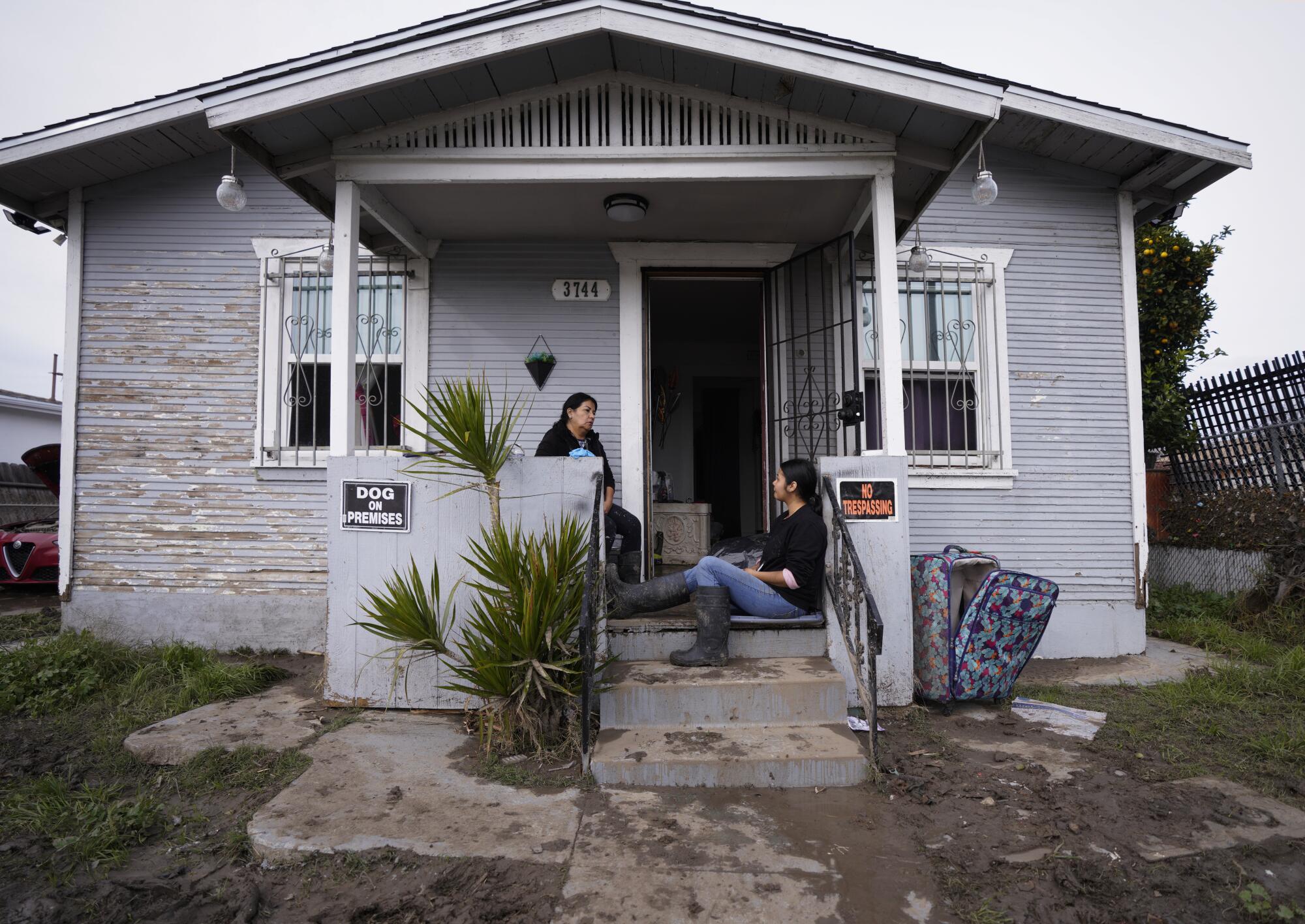 Flood victims sit on their front porch