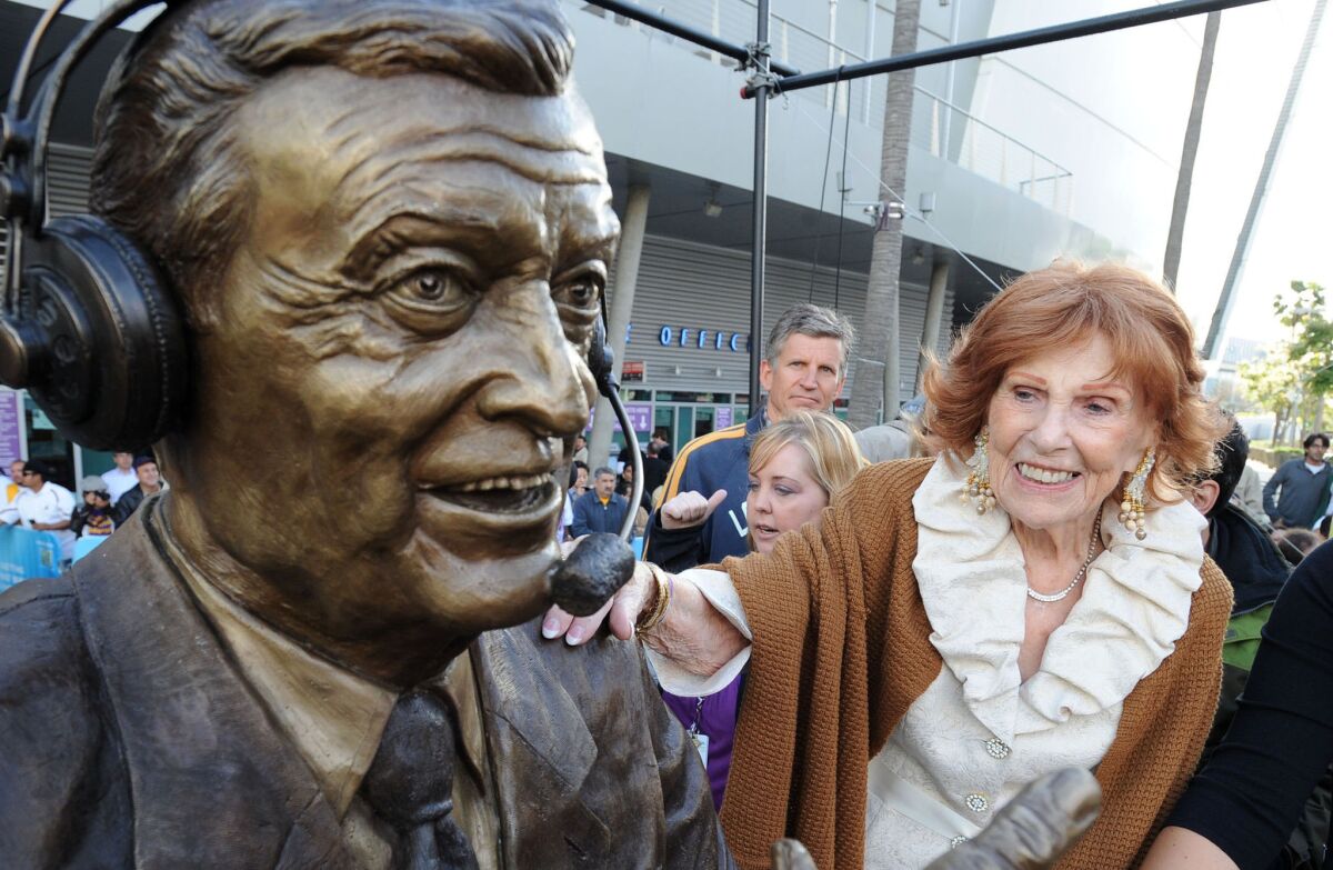 Marge Hearn touches the bronze statue of her late husband, Lakers play-by-play announcer Chick Hearn, before a Lakers playoff game in 2010.