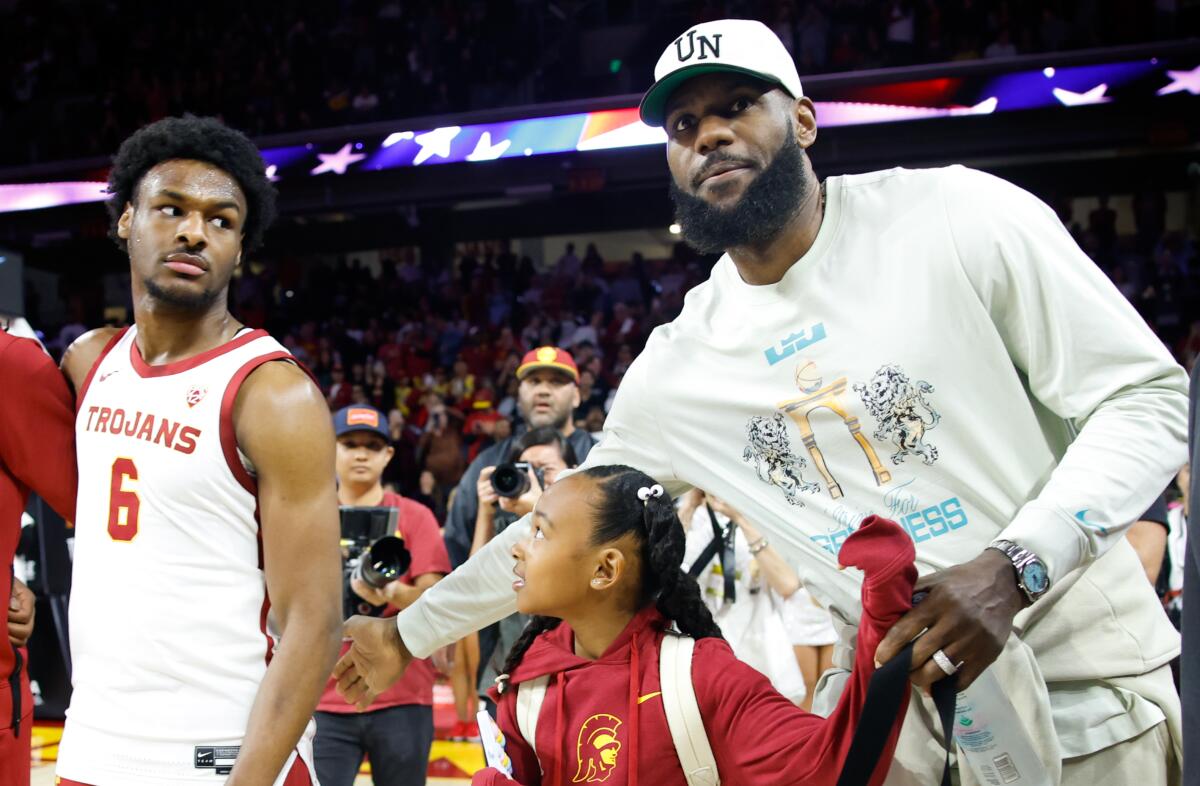 Lakers star LeBron James, right, pats his son and USC guard Bronny James on the back.