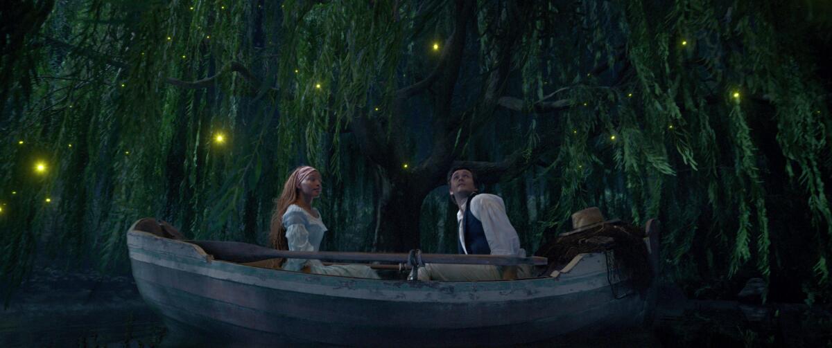 A woman and a man sitting in a boat under trees and fireflies