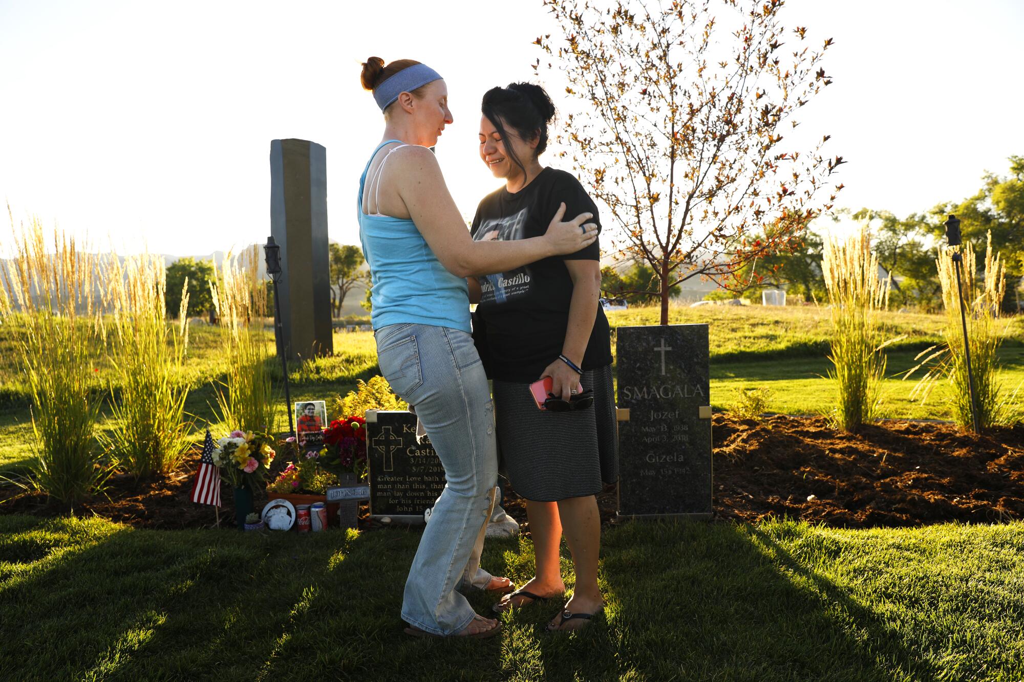 Francine Morin, left, comforts Kendrick Castillo's mother, Maria Castillo, at his grave site in Littleton, Colo.