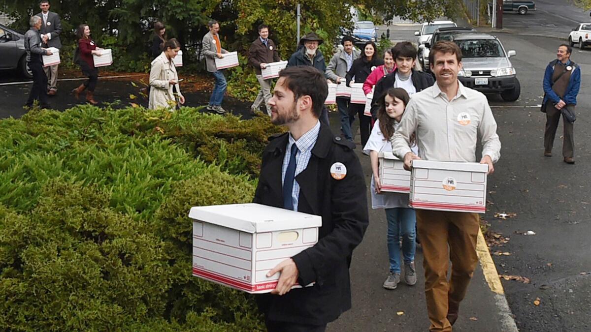 A group of "Carbon Washington" campaign supporters and organization members deliver signatures in support of putting Initiative 732 on the Washington state ballot, in Olympia, Wash, last October.