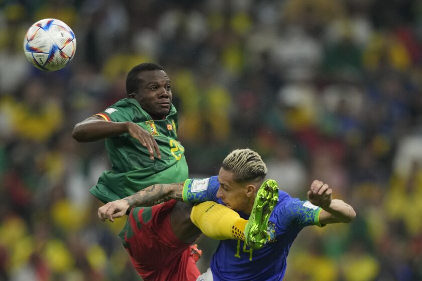 Cameroon's Tolo Nouhou, left, jumps to a ball with Brazil's Antony, right, during the World Cup group G soccer match between Cameroon and Brazil, at the Lusail Stadium in Lusail, Qatar, Friday, Dec. 2, 2022. (AP Photo/Frank Augstein)