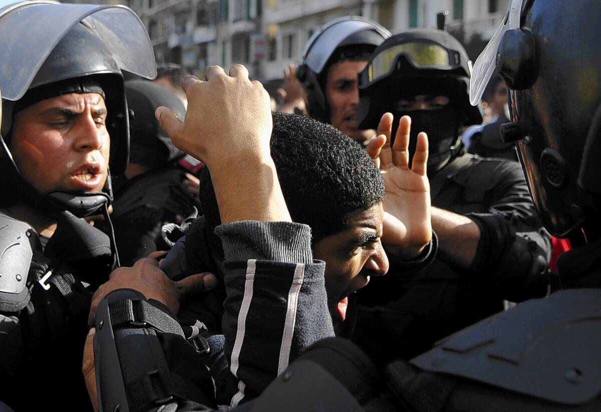 Egyptian police detain a supporter of the Muslim Brotherhood during clashes in the port city of Alexandria. Rights groups have singled out the government for criticism over what they say are rights abuses.