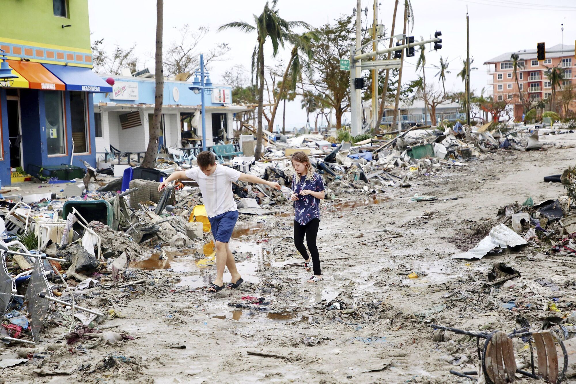 Jake Moses, left, and Heather Jones explore a section of destroyed businesses at Fort Myers Beach, Fla.