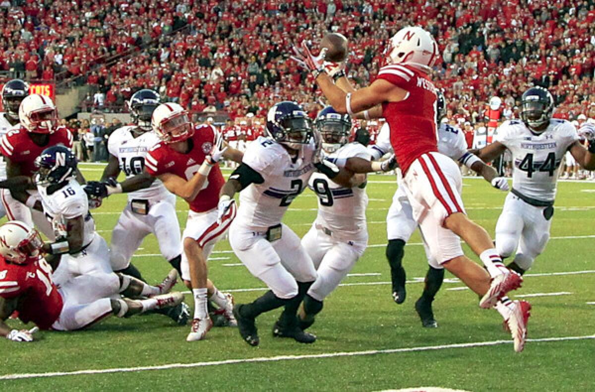 Nebraska receiver Jordan Westerkamp catches the game-winning touchdown pass over Northwestern defensive back Dwight White (2), safety Jimmy Hall (9) and linebacker Chi Chi Ariguzo (44) on the last play of the game Saturday in Lincoln, Neb.