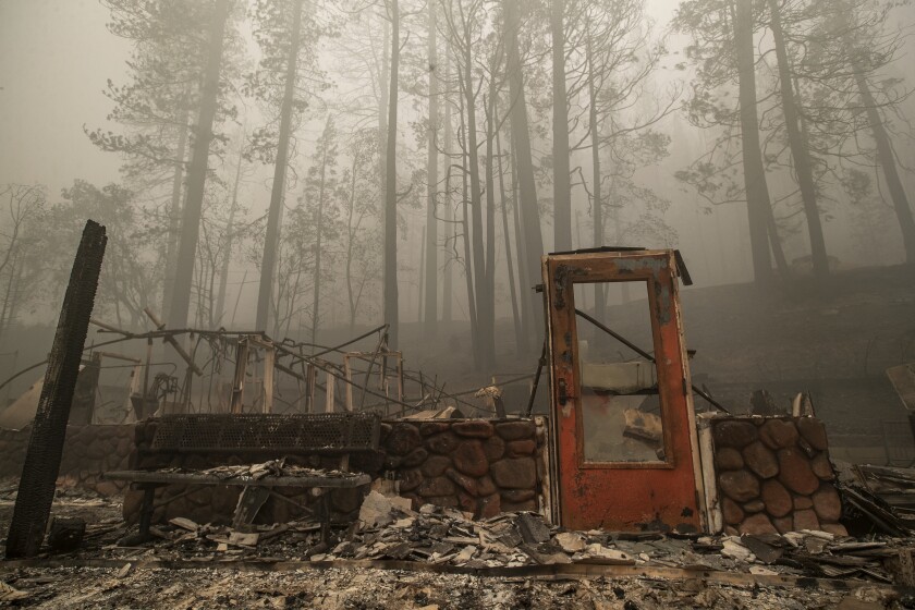 A door stands upright among the rubble from the Dixie fire.