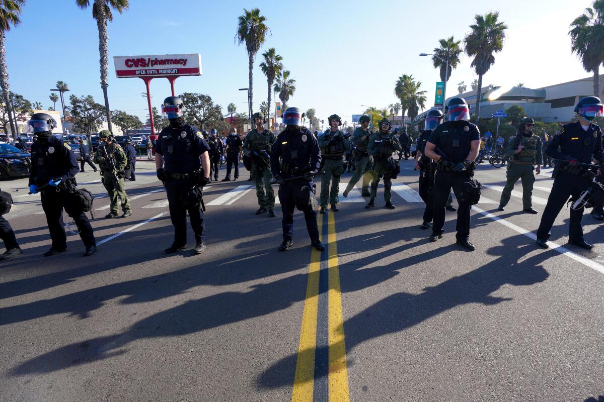 After a clash with anti-fascists, SDPD officers take up positions on Mission Boulevard
