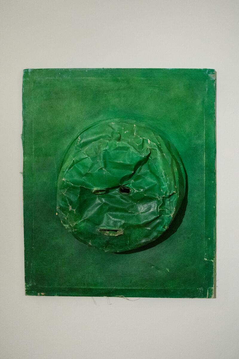 A green piece of art with a raised, 3-D center