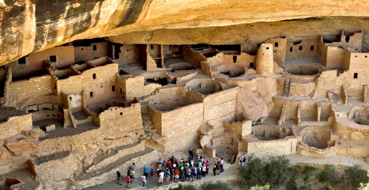 A ranger leads a group of visitors on a tour. These miniature cities carved into the cliffs were originally inhabited by the Ancestral Pueblo people (also known as Anasazi) between 550 and 1200.