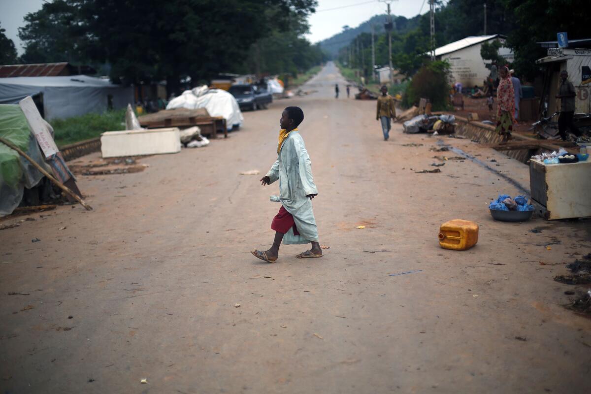 A child walks across a street in the PK12 neighborhood of Bangui, where Muslims are waiting to be evacuated from the Central African Republic.