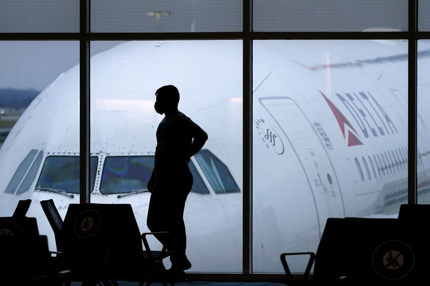 A Delta Air Lines jetliner parked outside an airport terminal.