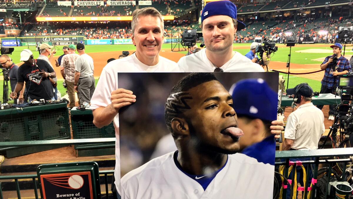 Blaise D’Sylva, left, and J.R. Edwards display their Puig poster at Minute Maid Park during Game 3.