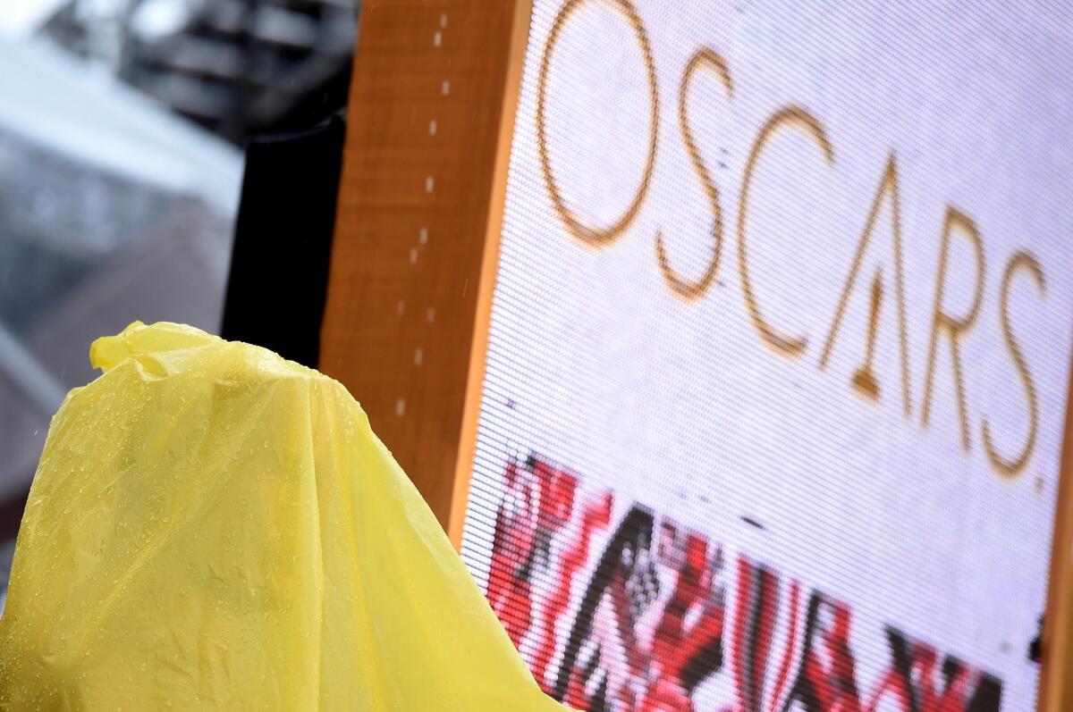 An Oscar statuette is covered as rain falls on the red carpter before the 87th Annual Academy Awards at Hollywood & Highland Center. Protests are planned over what critics say is a lack of diversity in the Oscars nominations.