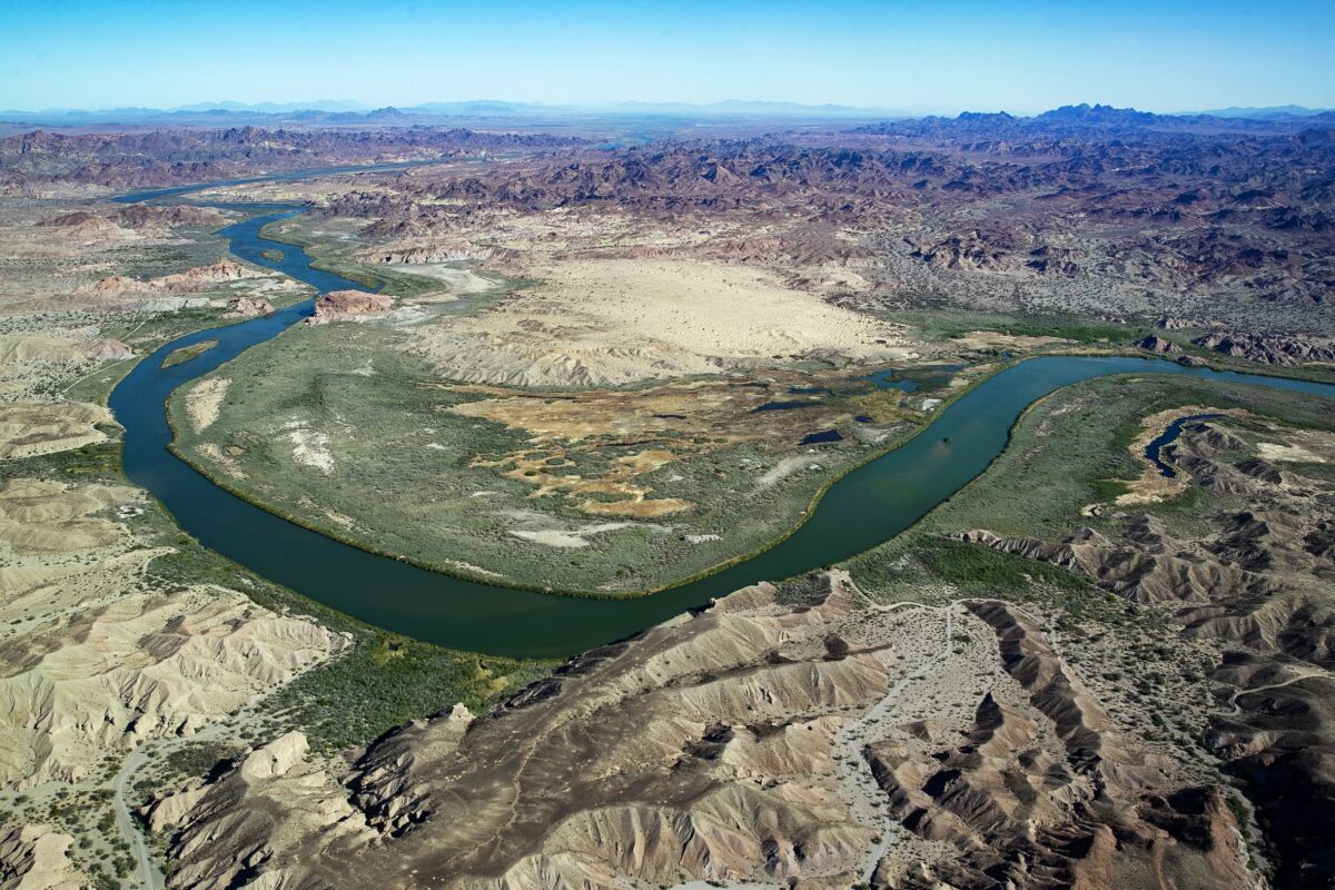 A dark green river winds through a generally arid landscape.