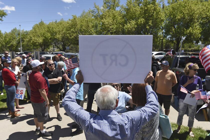FILE - In this May 25, 2021, file photo, a man holds up a sign against Critical Race Theory during a protest outside a Washoe County School District board meeting in Reno, Nev. Developed in the 1970s and '80s, critical race theory is a way of thinking about America’s history through the lens of racism. It centers on the idea that racism is systemic in the nation’s institutions and that they function to maintain the dominance of whites. (Andy Barron/Reno Gazette-Journal via AP, File)