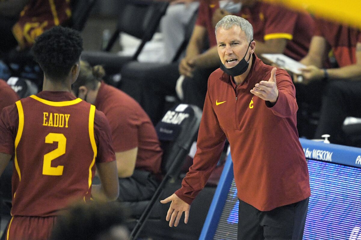 USC coach Andy Enfield talks to guard Tahj Eaddy during a game last season.