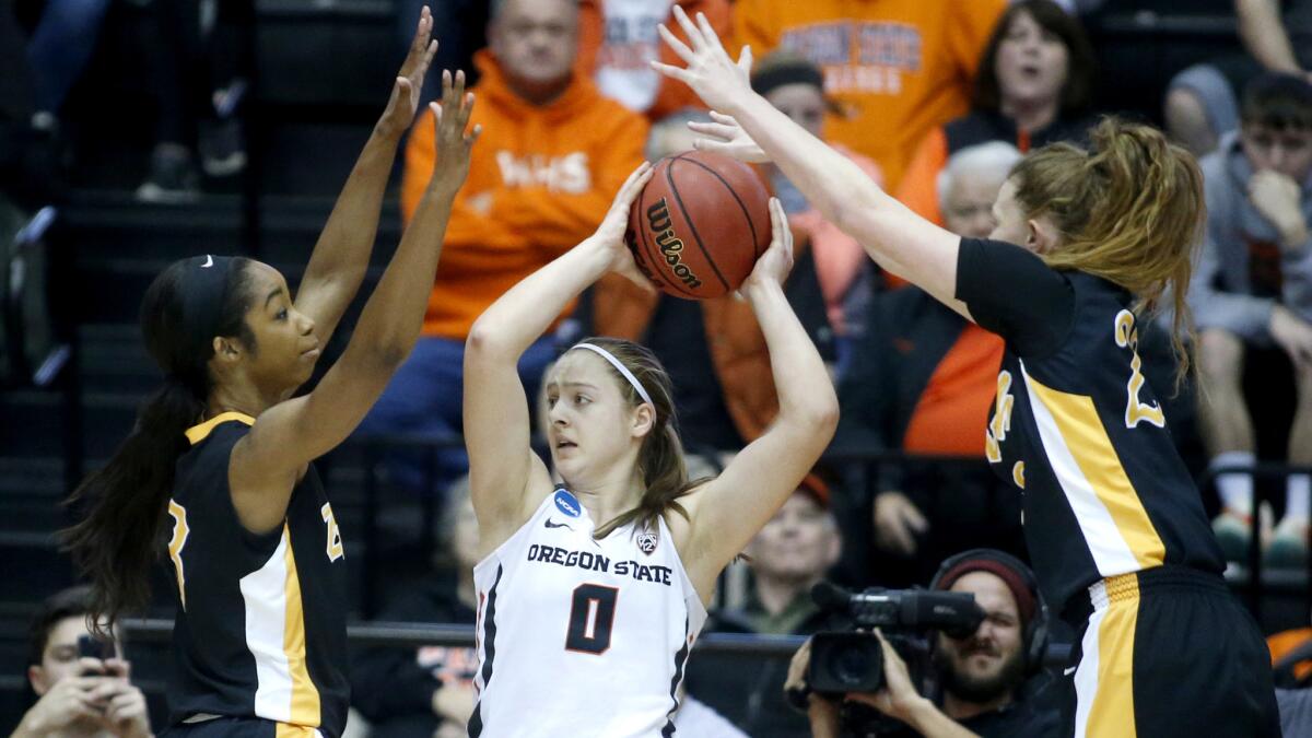 Oregon State's Mikayla Pivec (0) looks to pass against the double-team defense of Long Beach State's Chanterria Jackson, left, and Madison Montgomery during the first half Friday night.