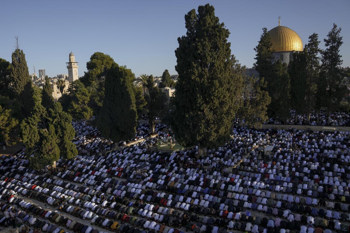Muslim worshipers offer Eid al-Adha prayers next to the Dome of the Rock shrine at the Al Aqsa Mosque compound in Jerusalem's Old City, Saturday, July 9, 2022. The major Muslim holiday, at the end of the hajj pilgrimage to Mecca, is observed around the world by believers and commemorates prophet Abraham's pledge to sacrifice his son as an act of obedience to God. (AP Photo/Mahmoud Illean)