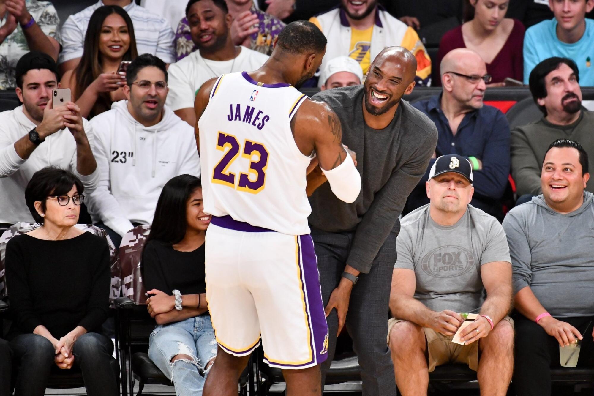 New Lakers star LeBron James greets Lakers legend Kobe Bryant during a game Nov. 17, 2019.