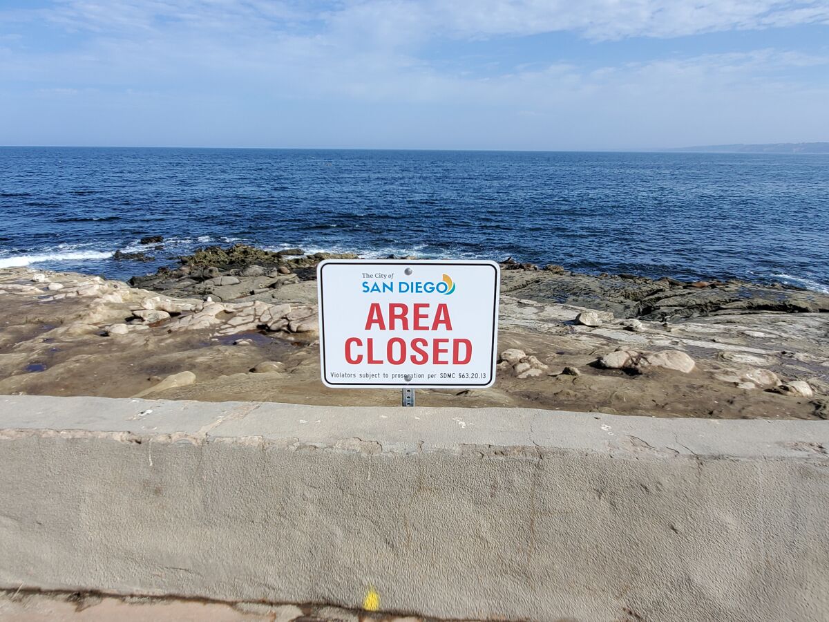 Signs like this along the concrete wall that lines Point La Jolla direct people away from the bluffs.