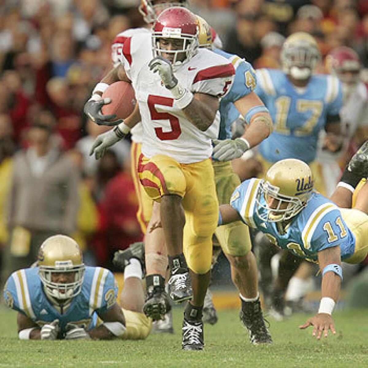 USC running back Reggie Bush breaks free from UCLA's Trey Brown, left, and Dennis Keyes to score on a 78-yard touchdown.