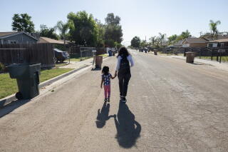 a woman and her daughter are shown walking from behind.