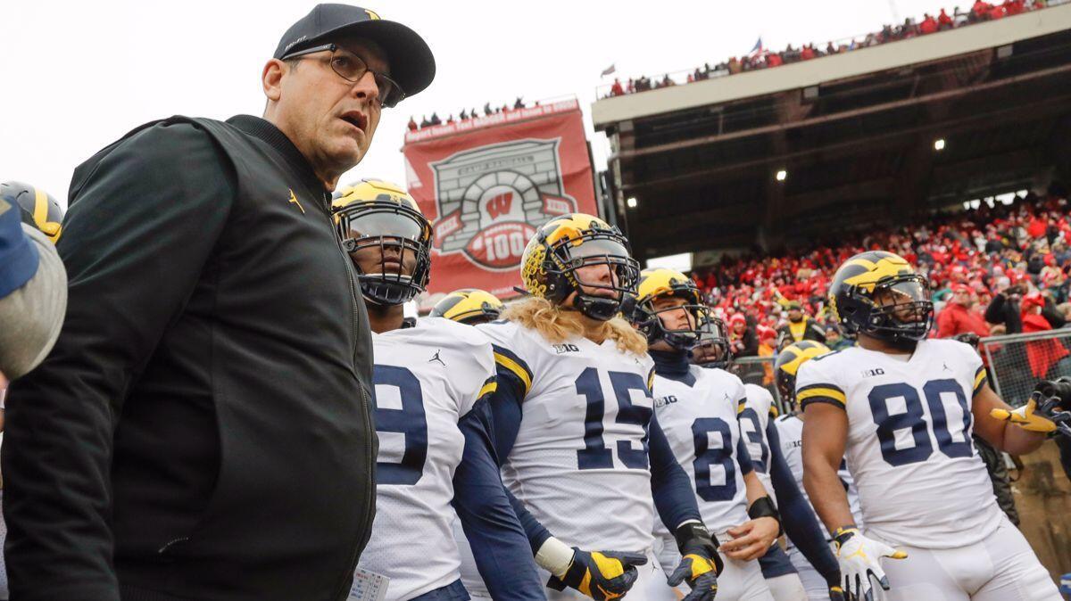 Michigan head coach Jim Harbaugh leads his team to the field before a game against Wisconsin on Saturday.